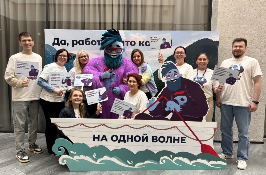 The Development Week team with the mascot at the “On the same wave” photo zone.