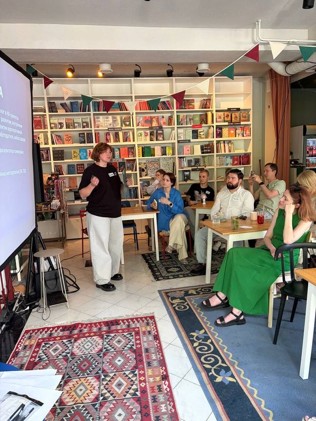 Viktoriia running an HR Illusions Lab session in a bookshop café.