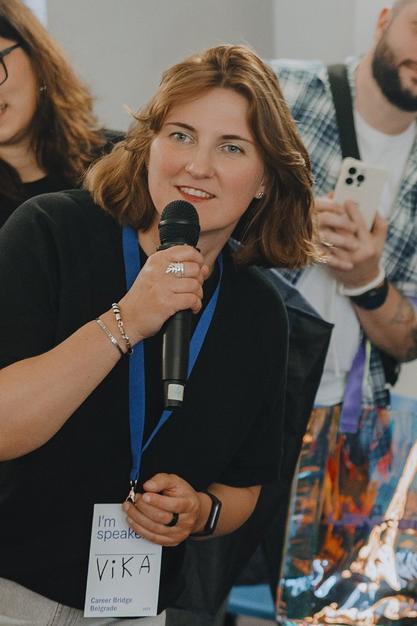 Viktoriia Bandorina smiling and speaking into a microphone.